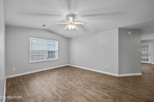 spare room featuring ceiling fan, a healthy amount of sunlight, lofted ceiling, and dark wood-type flooring