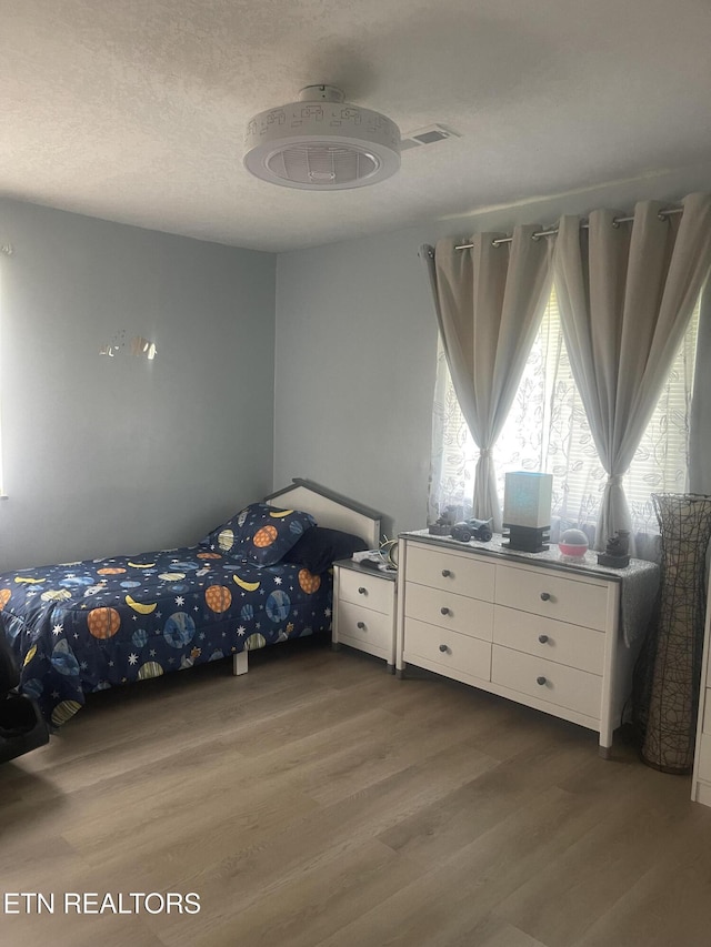 unfurnished bedroom with hardwood / wood-style floors and a textured ceiling