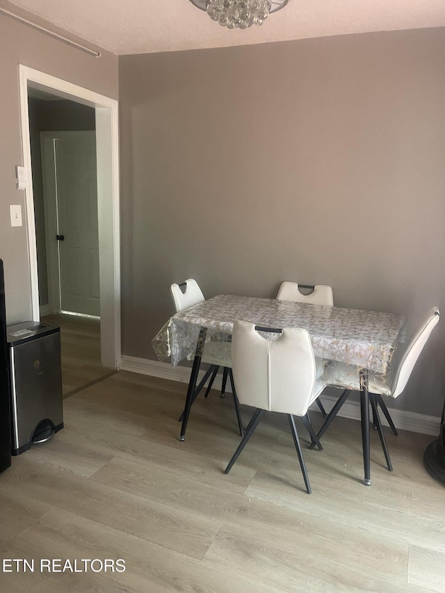 dining space featuring a chandelier and light hardwood / wood-style floors