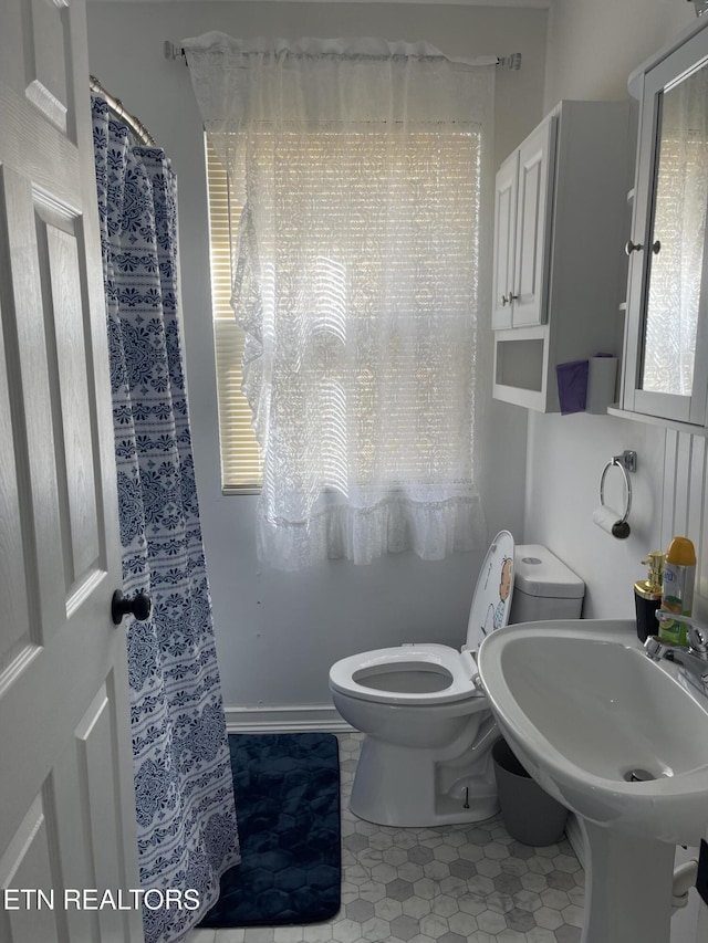 bathroom featuring tile patterned floors, toilet, and sink