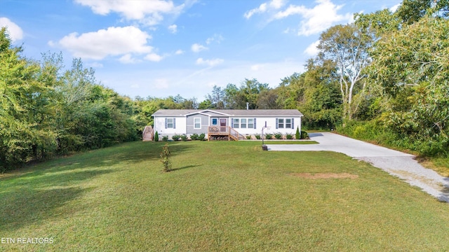 view of front of property with a deck and a front lawn