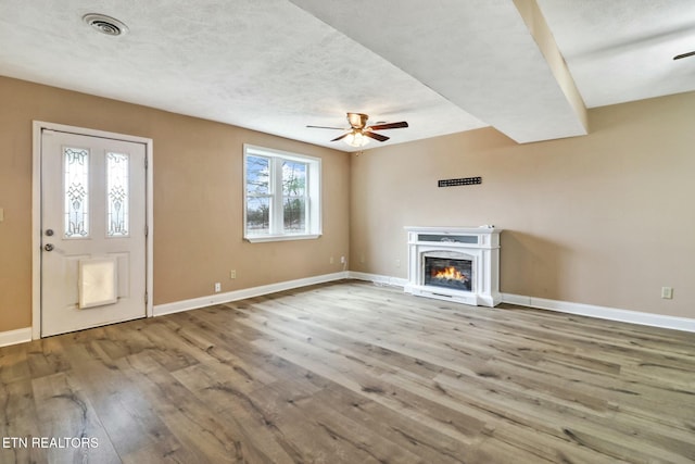 unfurnished living room with hardwood / wood-style floors and ceiling fan