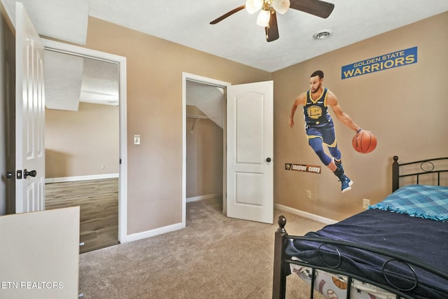 carpeted bedroom with ceiling fan, a closet, and a walk in closet