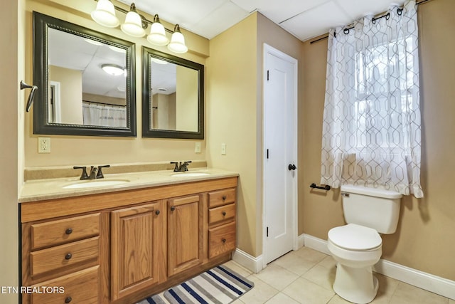 bathroom with toilet, vanity, and tile patterned flooring