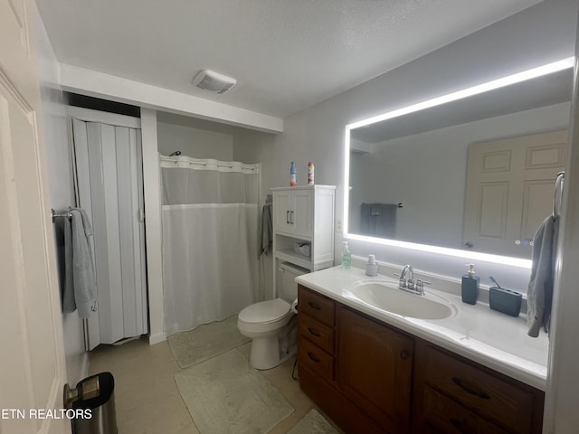 bathroom featuring vanity, a textured ceiling, and toilet