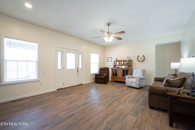 living room with ceiling fan and dark wood-type flooring