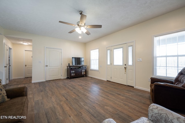 living room featuring a textured ceiling, dark hardwood / wood-style flooring, and ceiling fan