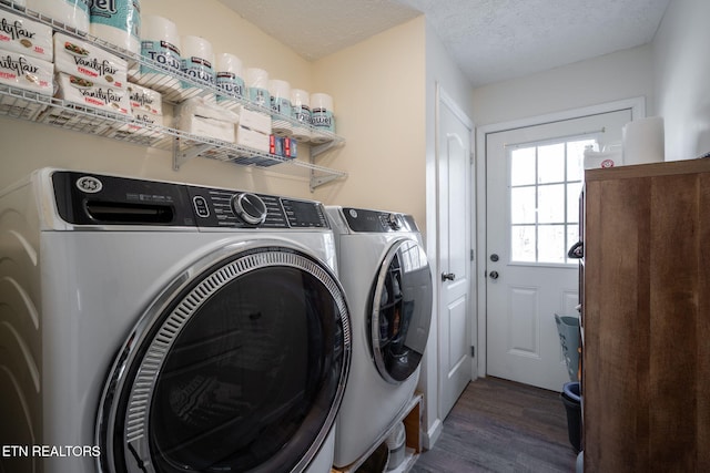 laundry area with dark hardwood / wood-style floors, washing machine and dryer, and a textured ceiling