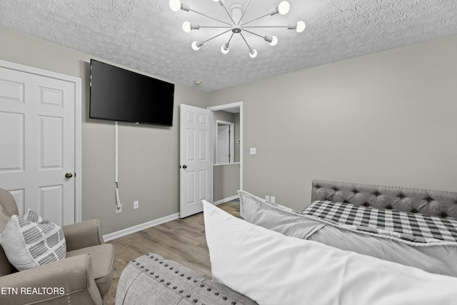 2133 Duck Pond Ln, Sevierville, TN 37876 - bedroom featuring a textured ceiling, light hardwood / wood-style flooring, and a chandelier