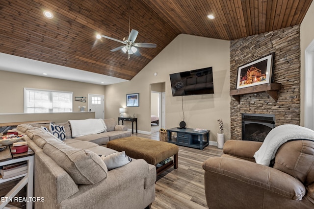 living room featuring light wood-type flooring, high vaulted ceiling, a fireplace, ceiling fan, and wooden ceiling