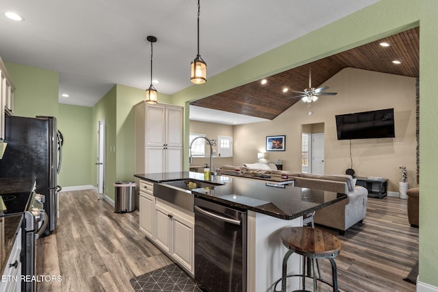 kitchen with sink, white cabinetry, a kitchen breakfast bar, an island with sink, and appliances with stainless steel finishes