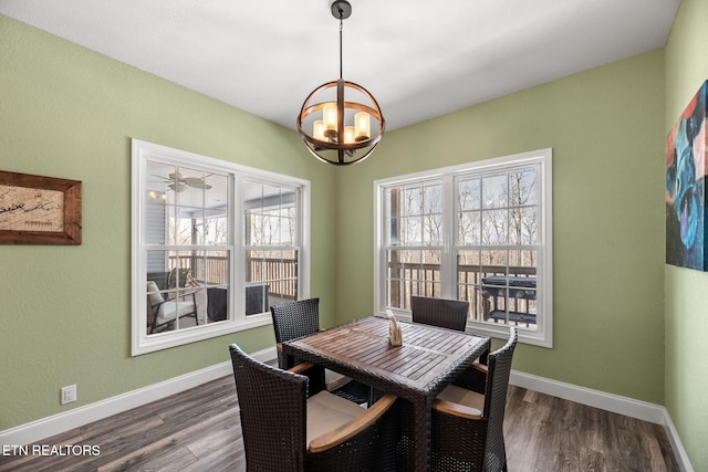 dining area featuring ceiling fan with notable chandelier and dark hardwood / wood-style floors