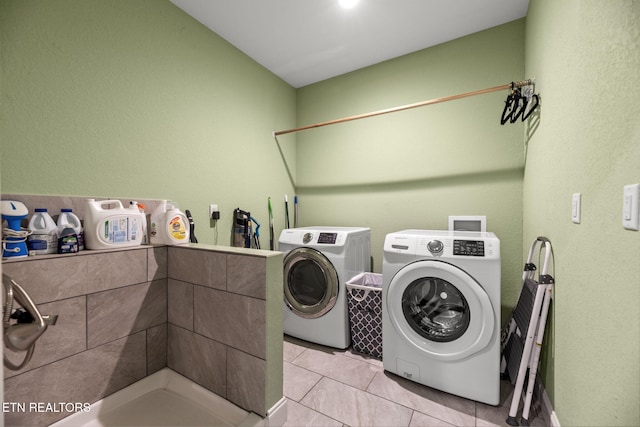 laundry area with light tile patterned floors and washer and clothes dryer