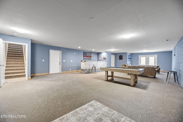 recreation room featuring a textured ceiling and french doors