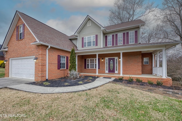 view of front of home with a garage, covered porch, and a front yard