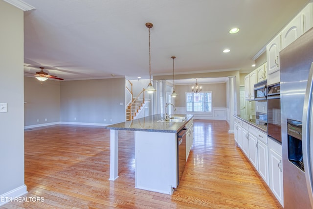 kitchen featuring crown molding, white cabinetry, sink, and pendant lighting