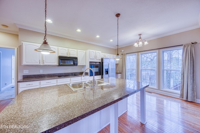 kitchen featuring white cabinets, sink, crown molding, and black appliances