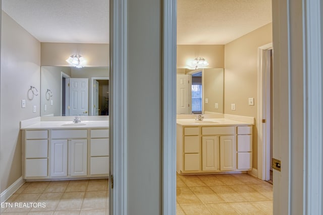 bathroom featuring tile patterned flooring, vanity, and a textured ceiling