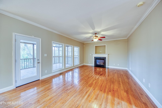 unfurnished living room featuring plenty of natural light, ceiling fan, light wood-type flooring, and ornamental molding