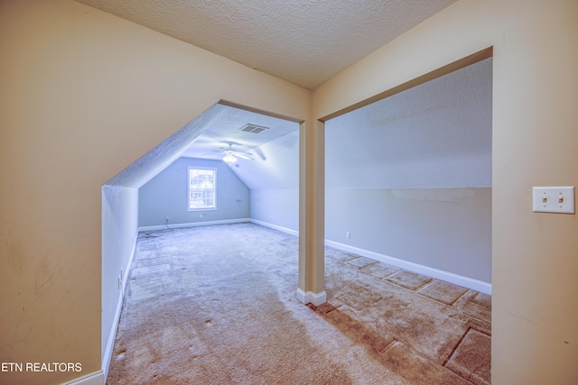 additional living space featuring carpet flooring, a textured ceiling, and vaulted ceiling