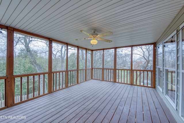 unfurnished sunroom with ceiling fan