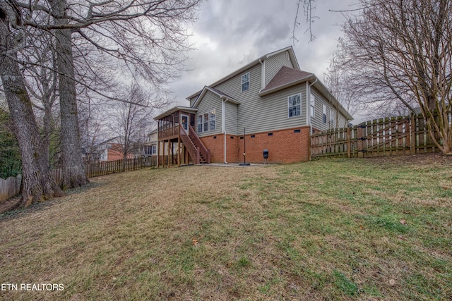 back of house featuring a deck and a lawn