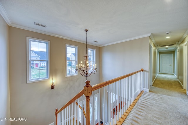 hall featuring carpet, a notable chandelier, crown molding, and a textured ceiling