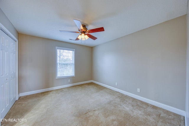 carpeted spare room with ceiling fan