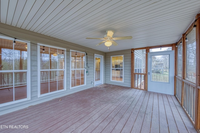 unfurnished sunroom featuring ceiling fan and plenty of natural light