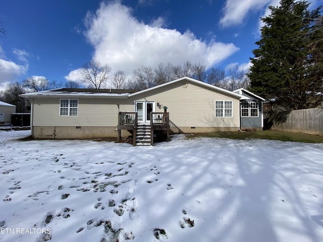 snow covered house featuring a wooden deck