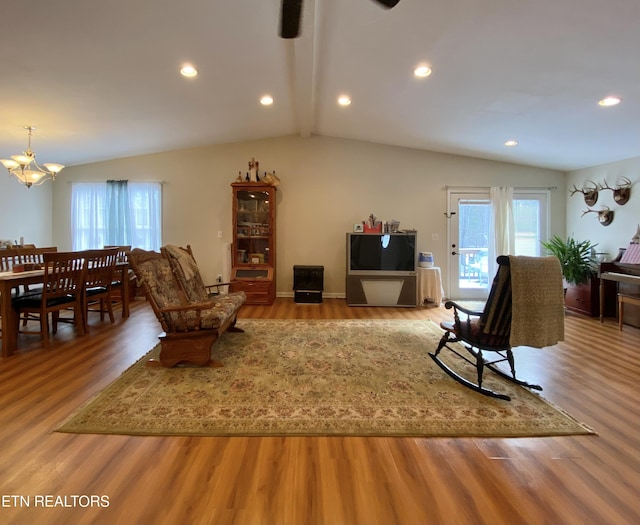 living room featuring an inviting chandelier, vaulted ceiling with beams, and hardwood / wood-style floors