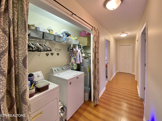 washroom featuring water heater, separate washer and dryer, and light hardwood / wood-style flooring