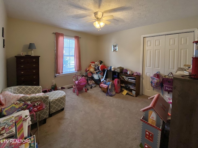 bedroom featuring ceiling fan, carpet floors, a closet, and a textured ceiling