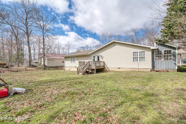 rear view of property with crawl space, a deck, and a lawn