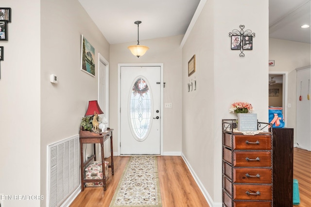 foyer entrance featuring wood finished floors, visible vents, and baseboards