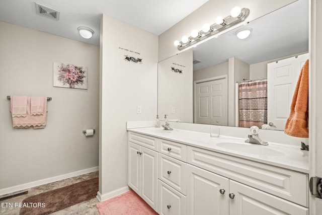 bathroom with visible vents, a sink, baseboards, and double vanity