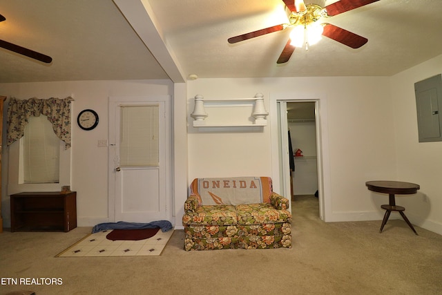 living area featuring ceiling fan, light colored carpet, and electric panel