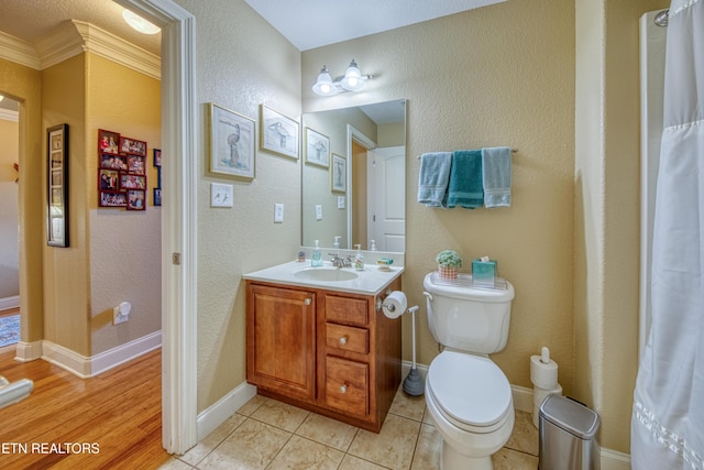 bathroom featuring toilet, vanity, tile patterned floors, and ornamental molding