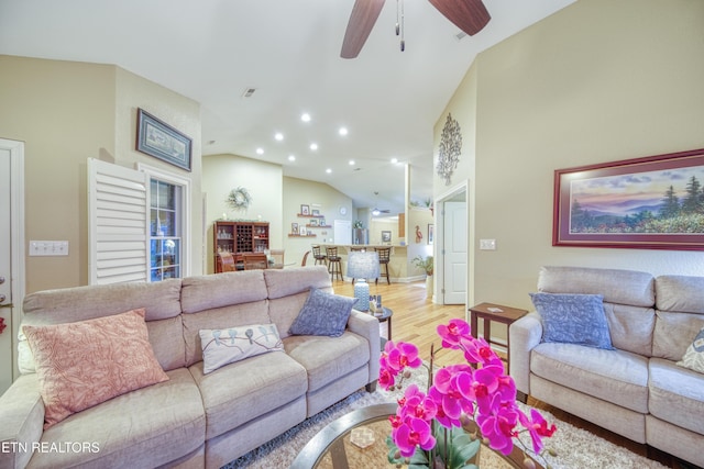 living room featuring hardwood / wood-style floors, vaulted ceiling, and ceiling fan