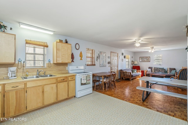 kitchen featuring electric stove, tasteful backsplash, sink, light parquet floors, and light brown cabinets