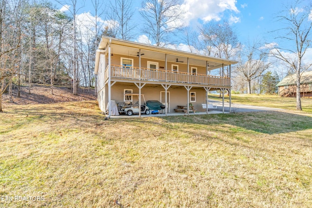 back of property featuring ceiling fan, a lawn, and a patio