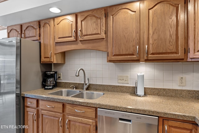 kitchen with light stone counters, sink, stainless steel appliances, and tasteful backsplash