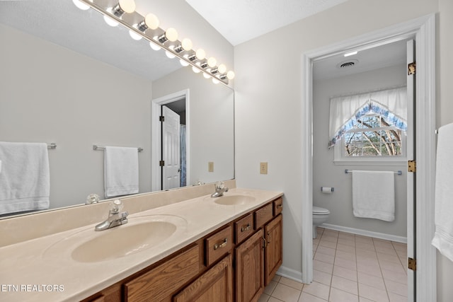 bathroom featuring tile patterned floors, vanity, toilet, and a textured ceiling