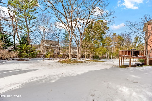 yard covered in snow featuring a wooden deck