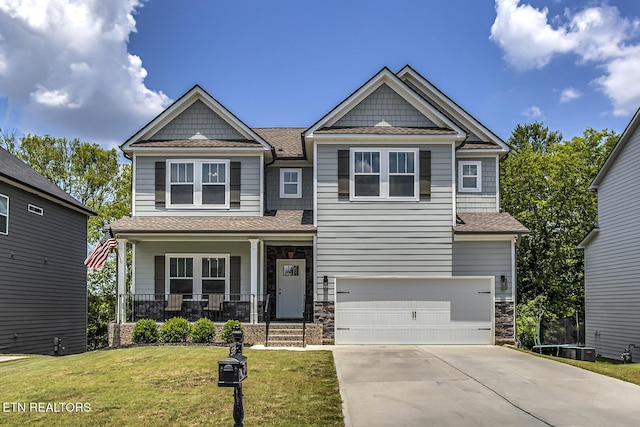 craftsman house with covered porch, a front yard, and a garage