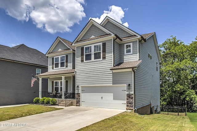 craftsman inspired home featuring covered porch, a garage, and a front lawn