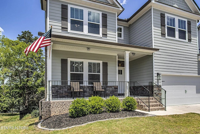 view of front of home featuring covered porch and a garage