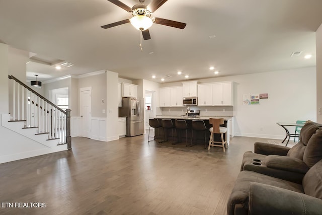 living room with ceiling fan, dark hardwood / wood-style floors, and crown molding