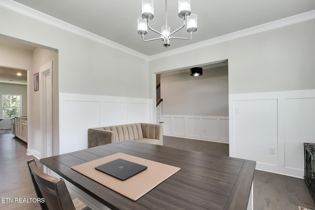 dining area featuring crown molding, dark hardwood / wood-style floors, and a notable chandelier