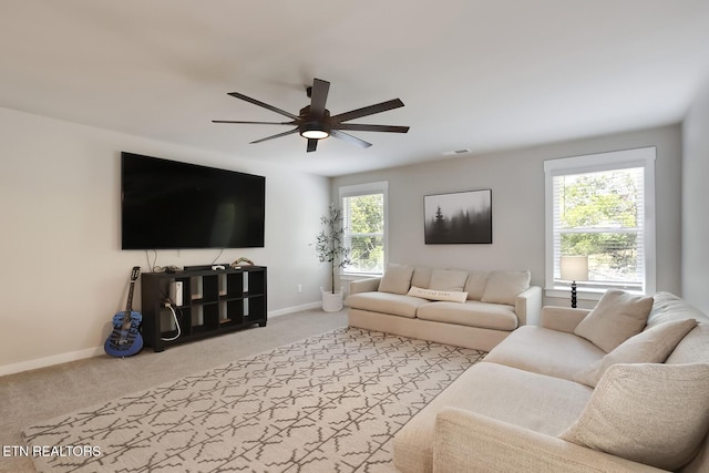 carpeted living room with ceiling fan and a healthy amount of sunlight